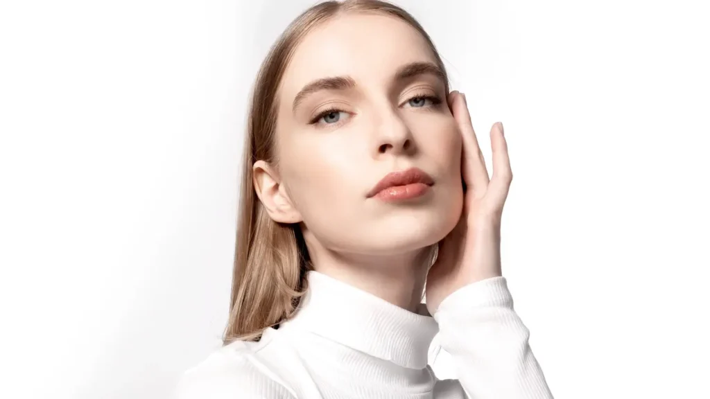 Femme dans un bureau au maquillage impeccable grâce à un fond de teint longue tenue au fini naturel de la marque Mihi.