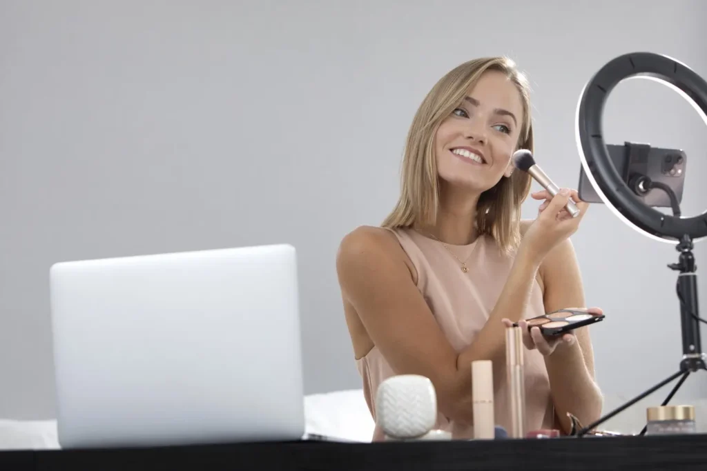 Jeune femme se prenant en photo avec des produits de beauté - Devenir Ambassadrice Beauté